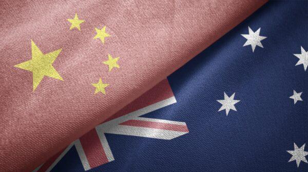 The Chinese Communist Party (CCP) flag encroaches onto the Australian flag. (Oleksii / Adobe Stock)
