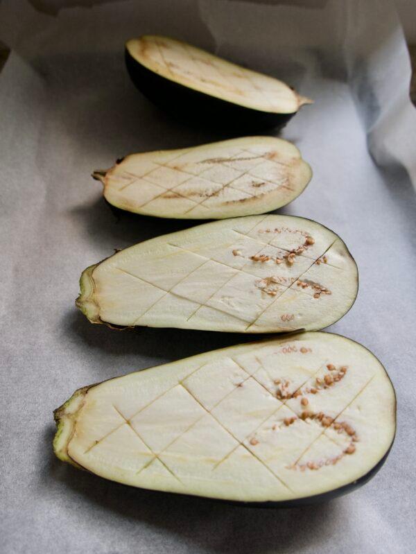 Score the flesh of the eggplants and bake until soft and creamy.