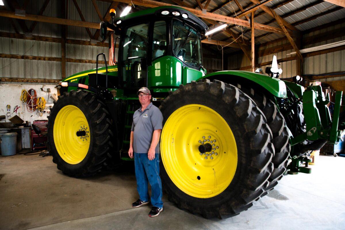 A farm technician in front of a tractor at a farm south of Lincoln, Neb., on June 24, 2021. (Petr Svab/The Epoch Times)