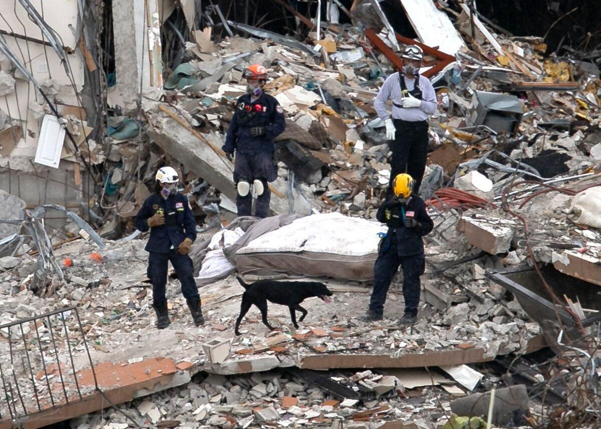 South Florida Urban Search and Rescue team look through rubble for survivors at the partially collapsed Champlain Towers South condo building in Surfside, Fla., on June 28, 2021. (Matias J. Ocner/Miami Herald via AP)
