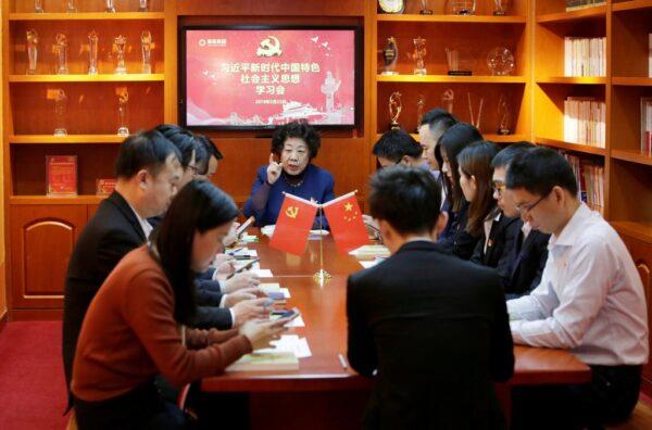 Communist Party members using the Xuexi Qiangguo app during a weekly meeting in Beijing in February 2019. Tens of millions of Chinese are now using the app, often under pressure from the regime. (Jason Lee/Reuters)