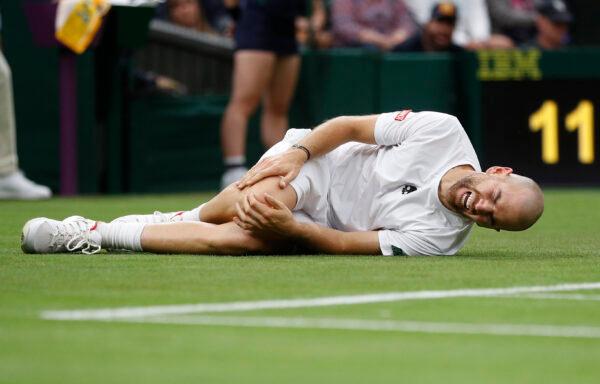 Fance's Adrian Mannarino reacts after sustaining an injury before retiring from his first round match against Switzerland's Roger Federer during Day Two of The Championships-Wimbledon 2021 at the All England Lawn Tennis and Croquet Club in London, England, on June 29, 2021. (Peter Nicholls/Reuters)