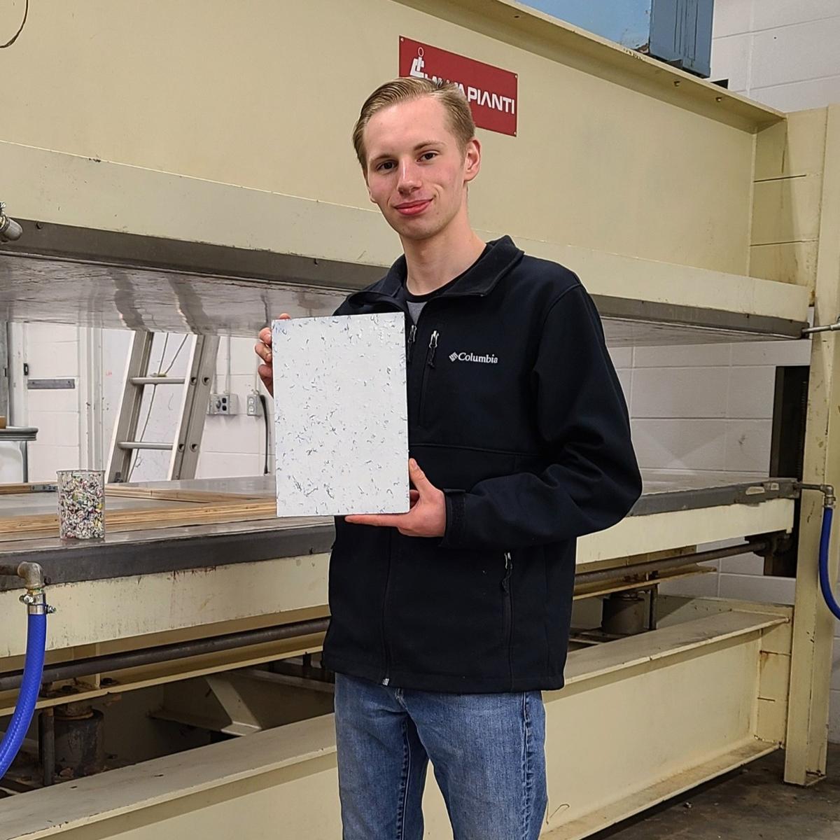 Myles Peterson, 18, CEO and founder of the Terracore Plastic Company, holds a Terra-Panel plywood alternative board. (Courtesy of <a href="https://www.facebook.com/terracoreplastics">Myles Peterson</a>)