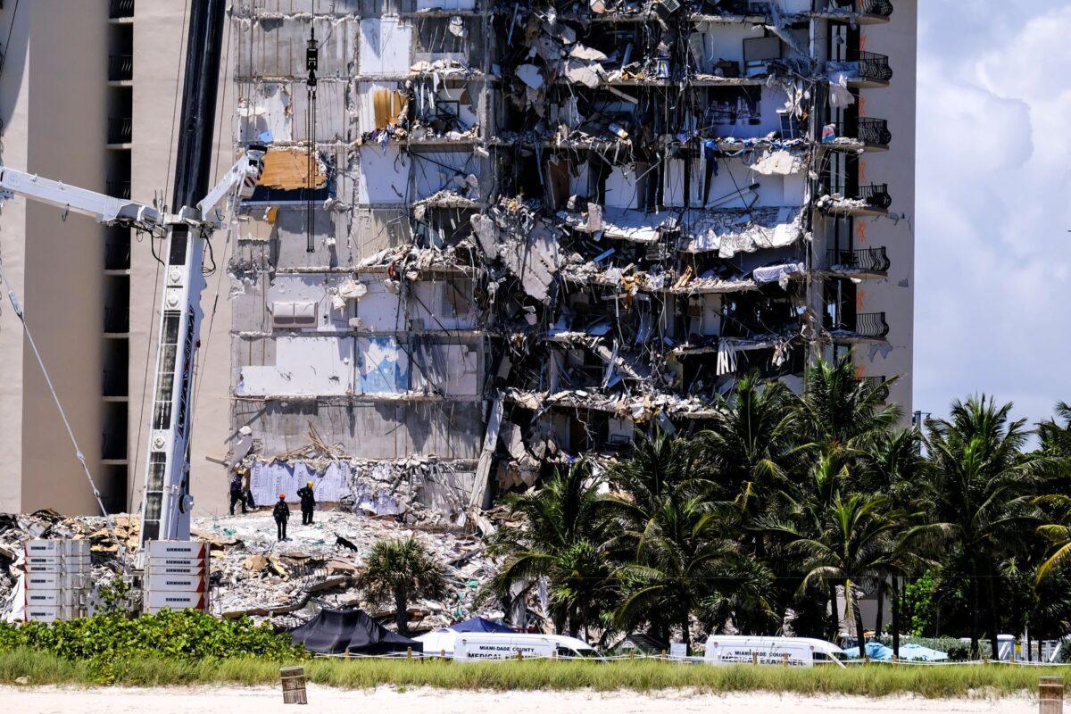 Search and rescue personnel with a rescue dog continue searching for victims days after a residential building partially collapsed in Surfside near Miami Beach, Fla., on June 27, 2021. (Maria Alejandra Cardona/Reuters)