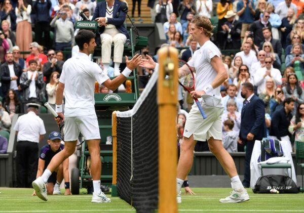 Serbia'a Novak Djokovic shakes hands with South Africa's Kevin Anderson after winning their first round match during the Wimbledon Championships in London, Britain on June 30, 2021. (Toby Melville/Reuters)