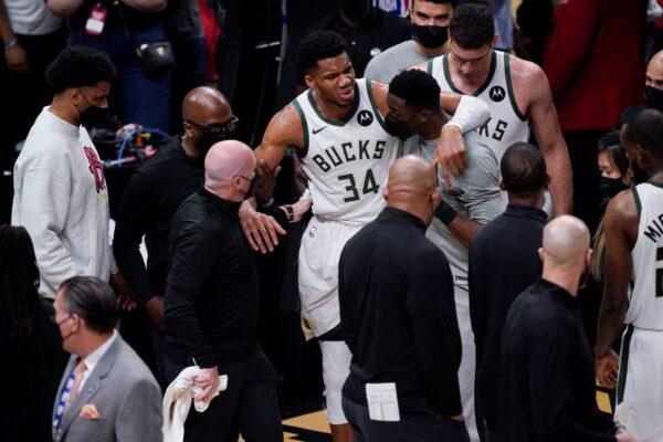 Milwaukee Bucks's Giannis Antetokounmpo (34) is helped off the court after he and Atlanta Hawks's Clint Capela fell during the second half of Game 4 of the NBA basketball Eastern Conference finals in Atlanta, on June 29, 2021. (Brynn Anderson/AP Photo)