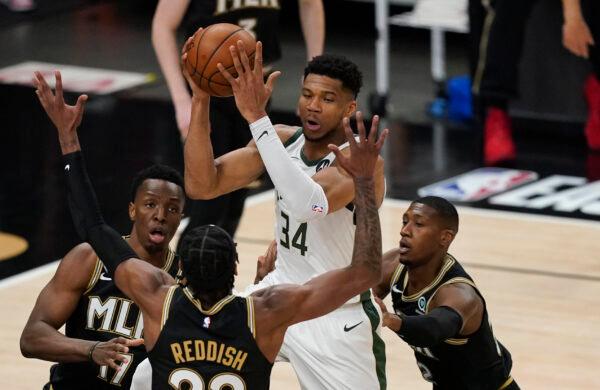 Milwaukee Bucks's Giannis Antetokounmpo (34) passes the ball as Atlanta Hawks's Cam Reddish (22) defends during the first half of Game 4 of the NBA basketball Eastern Conference finals in Atlanta, on June 29, 2021. (Brynn Anderson/AP Photo)
