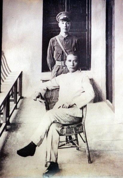 This file photo dated 16 June 1924 shows Dr. Sun Yat-sen, the founding father of the Republic of China, sitting on a chair at the Whampoa Military Academy. Standing behind him is Chiang Kai-shek, then president of the academy. (AFP via Getty Images)