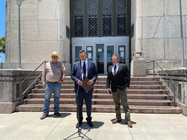 (L–R) Kinney County Sheriff Brad Coe, former Kansas Secretary of State Kris Kobach, and Kinney County Attorney Brent Smith stand outside the federal courthouse in Galveston, Texas, on July 1, 2021. (Charlotte Cuthbertson/The Epoch Times)