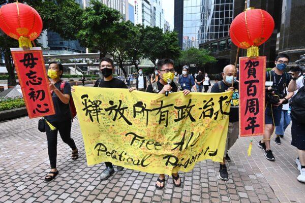 Four members of Hong Kong League of Social Democrats are marching on streets to urge the Beijing regime to release all political prisoners in Hong Kong on July 1, 2021. (Song Bilong/The Epoch Times)