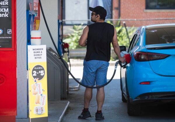 A man pumps gas into his vehicle at an Esso gas station in Toronto on June 15, 2021. (The Canadian Press/Tijana Martin)