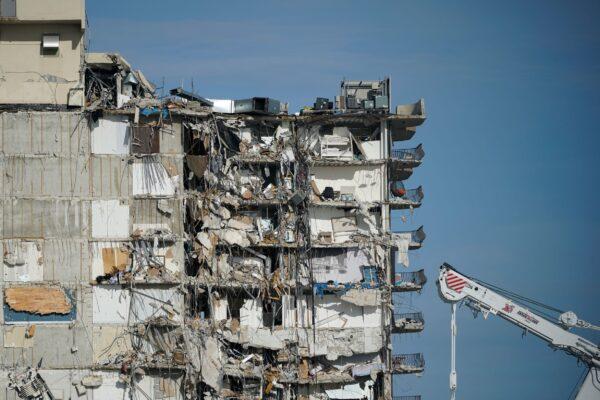 A parked crane sits beside the still standing section of Champlain Towers South, which partially collapsed last Thursday, as rescue efforts on the rubble below were paused out of concern about the stability of the remaining structure in Surfside, Fla., on July 1, 2021. (Mark Humphrey/AP Photo)
