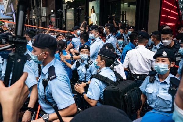 Police officers use tape to cordon off areas on the 24th anniversary of Hong Kong's handover from Britain in the Causeway Bay district in Hong Kong on July 1, 2021. (Anthony Kwan/Getty Images)