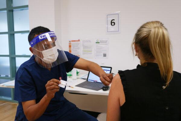 Registered Nurse, Mesfin Desalegn administers the Pfizer vaccine to a client at the St Vincent's Covid-19 Vaccination Clinic in Sydney, Australia on July 1, 2021. (Lisa Maree Williams/Getty Images)
