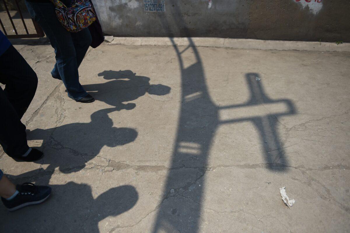 Worshippers walk past the shadow of a cross at the entrance to the "underground" Zhongxin Bridge Catholic Church, after a service celebrating the Feast of the Ascension in Tianjin, on May 24, 2015. (Greg Baker/AFP via Getty Images)