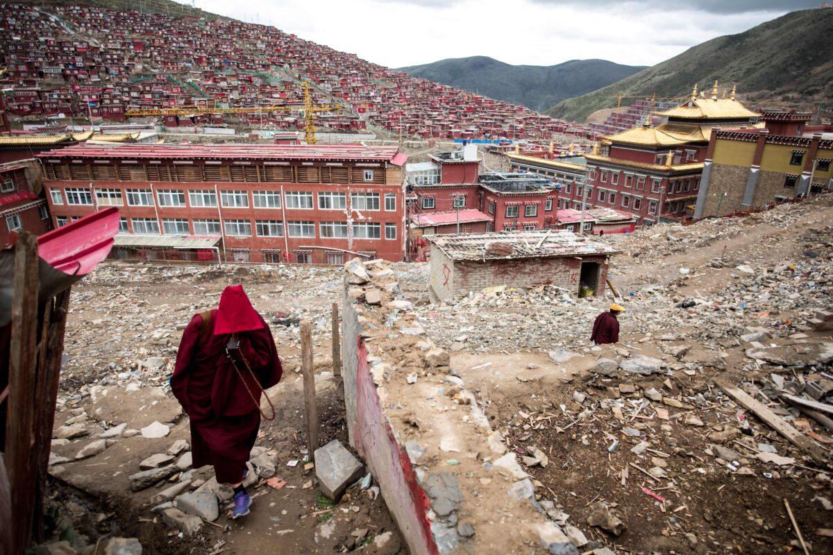 A nun walking amid the debris of demolished houses at the Larung Gar Buddhist Institute in Sertar county in southwest China's Sichuan province on May 29, 2017. (Johannes Eisele/AFP via Getty Images)