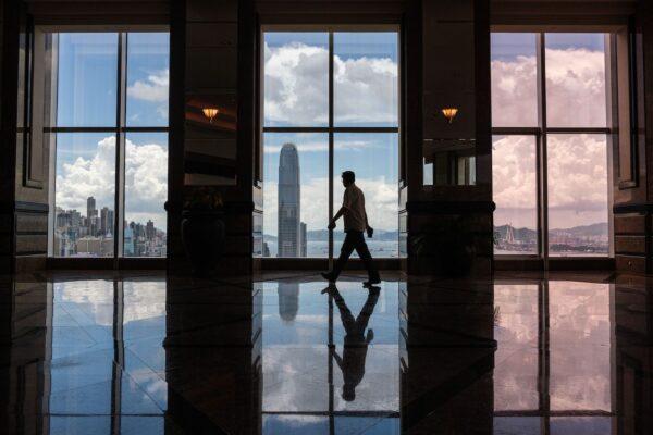 A man walks in front of windows showing a view of the skyline of Hong Kong on July 21, 2020. (Anthony Wallace/AFP via Getty Images)