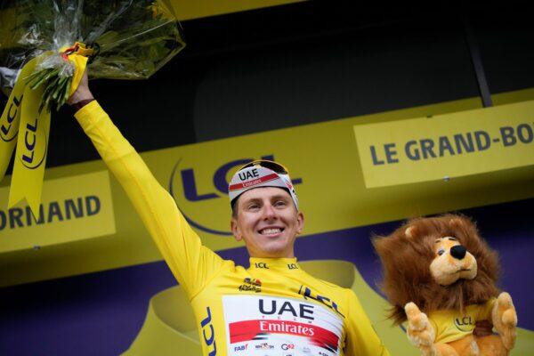 Slovenia's Tadej Pogacar, wearing the overall leader's yellow jersey, celebrates on the podium after the eighth stage of the Tour de France cycling race over 150.8 kilometers (93.7 miles) with start in Oyonnax and finish in Le Grand-Bornand, France, on July 3, 2021. (Christophe Ena/AP Photo)