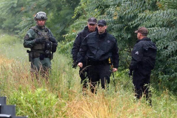 Police work on in the area of an hourslong standoff with a group of armed men that partially shut down Interstate 95, in Wakefield, Mass., on July 3, 2021. (Michael Dwyer/AP Photo)