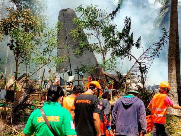 First responders work at the site after a Philippine air force Lockheed C-130 plane carrying troops crashed on landing in Patikul, Sulu province, Philippines, on July 4, 2021. (Armed Forces of the Philippines—Joint Task Force Sulu/Handout via Reuters)