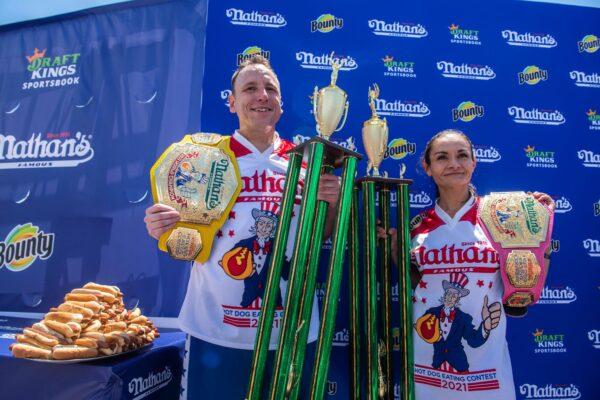 Winners Joey Chestnut and Michelle Lesco pose with their championship belts and trophies at the Nathan's Famous Fourth of July International Hot Dog-Eating Contest in Coney Island's Maimonides Park in the Brooklyn borough of New York City, on July 4, 2021. (Brittainy Newman/AP Photo)