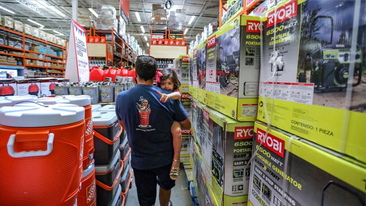 Frank Barakat carries his daughter Valentina, 2, through a shopping aisle dedicated for hurricane supplies in Miami, Fla., on July 3, 2021. (Al Diaz/Miami Herald via AP)