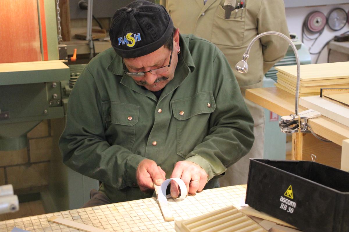 A staff member cuts wood. (Wibke Carter)