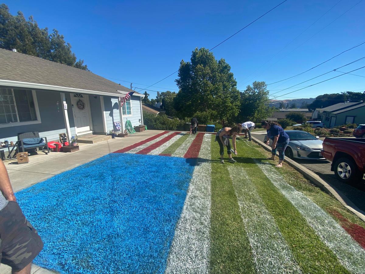 Erin, her husband, and friends render the American flag in chalk spray paint on their front lawn. (Courtesy of <a href="https://www.facebook.com/erin.mckay.5070">Erin McKay-Schnell</a>)