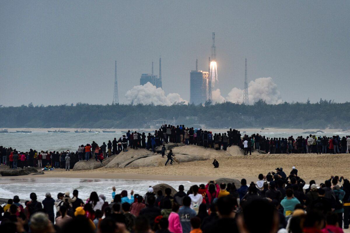 People watch a Long March-8 rocket, the latest China's Long March launch vehicle fleet, as it lifts off from the Wenchang Space Launch Center in China's Hainan Province on Dec. 22, 2020. (STR/AFP via Getty Images)