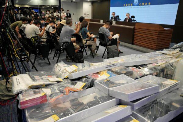 Police hold a news conference with confiscated evidence seen at front, at the police headquarters in Hong Kong, on July 6, 2021. (Kin Cheung/AP Photo)