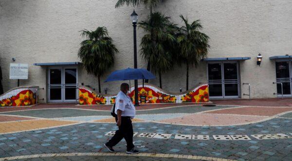 A man walks with an umbrella ahead of Tropical Storm Elsa in the Little Havana neighborhood of Miami, Fla., on July 5, 2021. (Shannon Stapleton/Reuters)