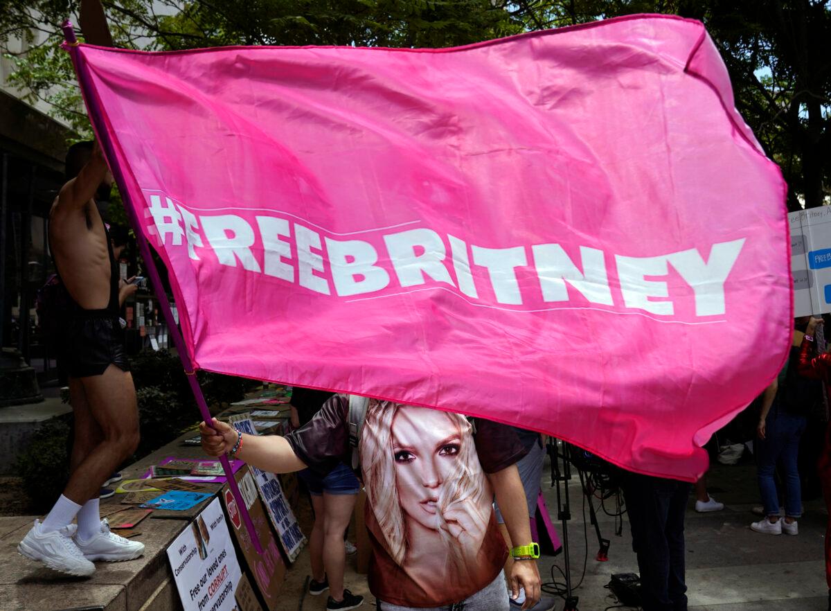 A Britney Spears supporter waves a "Free Britney" flag outside a court hearing at the Stanley Mosk Courthouse, in Los Angeles, Wednesday, June 23, 2021. (Chris Pizzello/AP Photo)