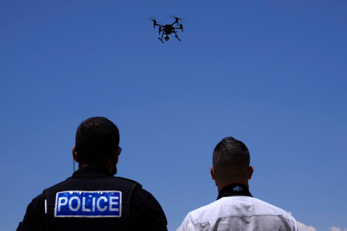 British police officers control a drone with cameras within the British military base, Cyprus, on July 6, 2021. (Petros Karadjias/AP Photo)