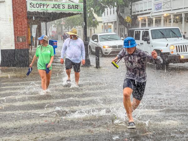 Pedestrians dash across the intersection of Greene and Duval streets as Tropical Storm Elsa passes Key West, Fla., on Tuesday, July 6, 2021. (Rob O'Neal/The Key West Citizen via AP)