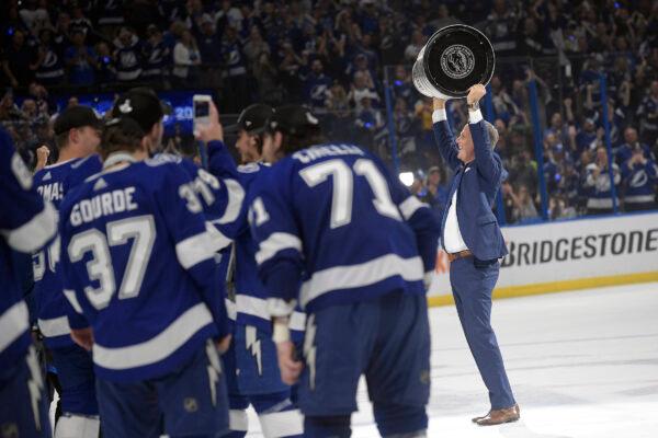 Tampa Bay Lightning head coach Jon Cooper hoists the Stanley Cup after the team defeated the Montreal Canadiens in Game 5 of the NHL hockey Stanley Cup finals, in Tampa, Fla., on July 7, 2021. (Phelan Ebenhack/AP Photo)