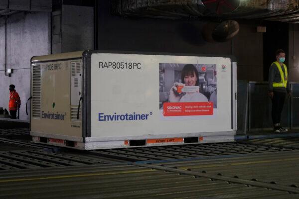 Workers load a container of the first batch of China's Sinovac Biotech CoronaVac vaccine for COVID-19 onto a truck at a cargo terminal on February 19, 2021 in Hong Kong, China. (Kin Cheung - Pool/Getty Images)