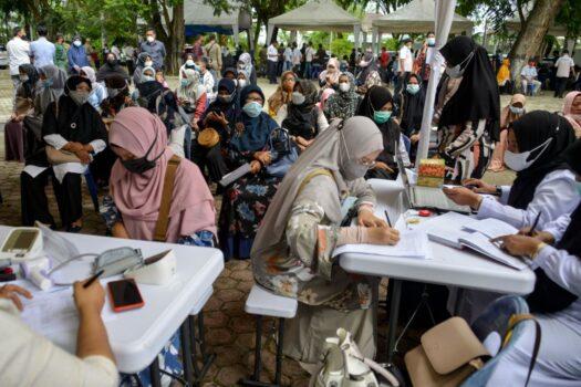 People wait before receiving a dose of Sinovac's Covid-19 coronavirus vaccine during a vaccination drive in Banda Aceh, Indonesia, on July 7, 2021. (Chaideer Mahyuddin/AFP via Getty Images)