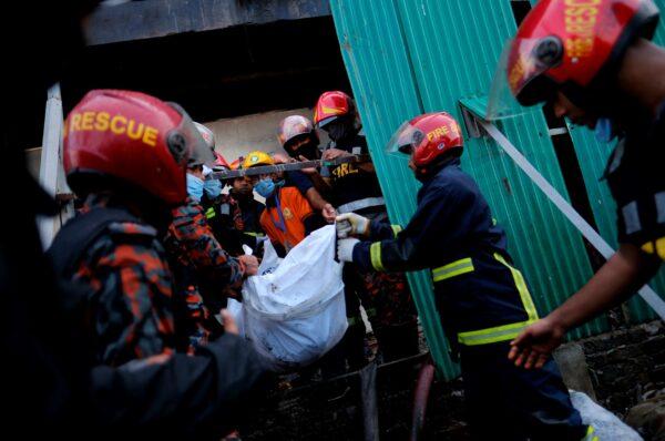 Firefighters carry the body of a victim at a food and beverage factory in Rupganj, outside Dhaka, Bangladesh, on July 9, 2021. (Mahmud Hossain Opu/AP Photo)