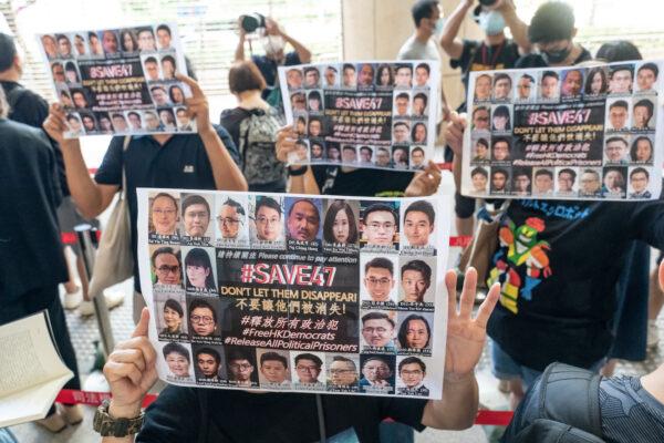 Supporters hold signs featuring images of some of the 47 pro-democracy activists outside the West Kowloon Magistrates' Courts ahead of a hearing in Hong Kong, China, on July 8, 2021. (Anthony Kwan/Getty Images)