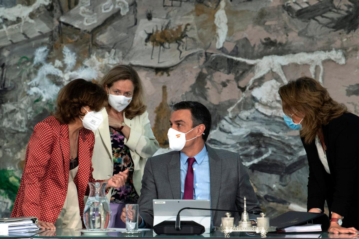 Spain's Prime Minister Pedro Sanchez (C), talks with Spain's Deputy Prime Minister Carmen Calvo (L), Spain's Deputy Prime Minister and Minister of Economic Affairs Nadia Calvino (2nd left), and Spain's Deputy Prime Minister and Minister of Ecological Transition and Demographic Challenge Teresa Ribera during a cabinet meeting at the Moncloa Palace in Madrid, on June 22, 2021. (Borja Puig de la Bellacasa/Spanish Government via AP)