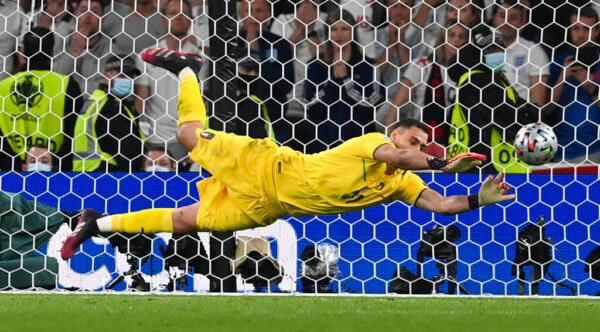 Italy's goalkeeper Gianluigi Donnarumma makes a save against England's Jadon Sancho during penalty shootout of the Euro 2020 soccer championship final match between England and Italy at Wembley Stadium in London, on July 11, 2021. (Paul Ellis/Pool via AP)