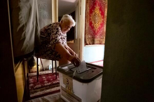 A woman casts her vote in a mobile ballot box, in Chisinau, Moldova, on July 11, 2021. (Aurel Obreja/AP Photo)