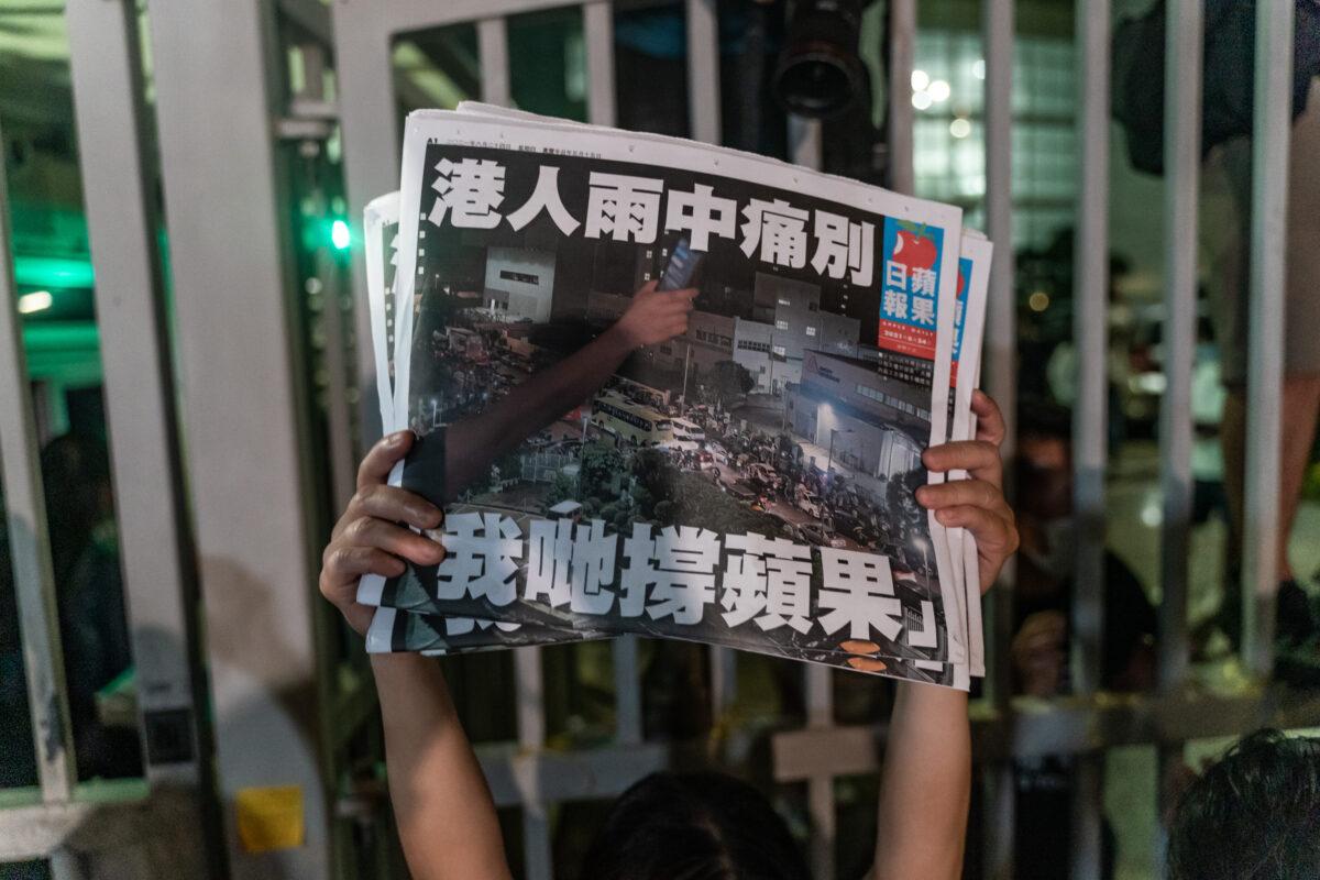 An employee holds up the latest copies of the Apple Daily newspaper outside at the offices in Hong Kong on June 24, 2021. (Anthony Kwan/Getty Images)
