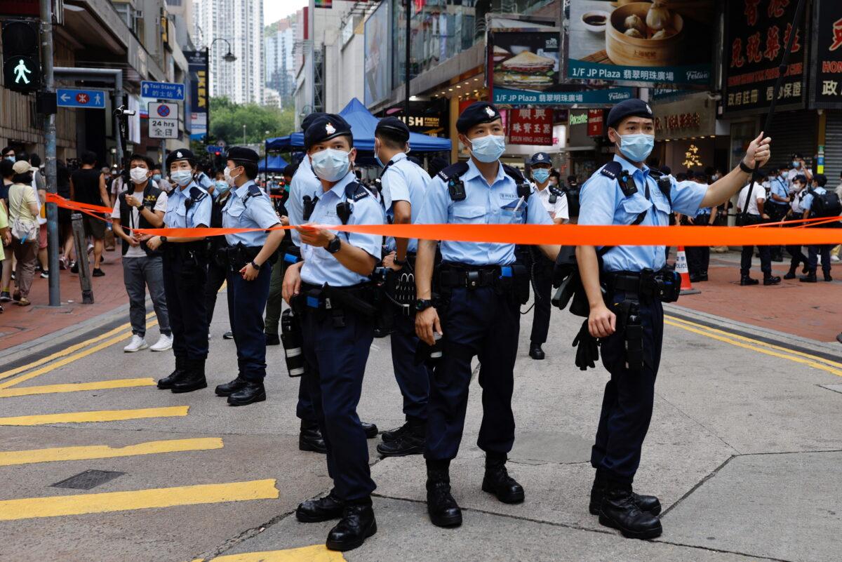 Police stand guard at Causeway Bay in Hong Kong, on July 1, 2021. (Tyrone Siu/Reuters)
