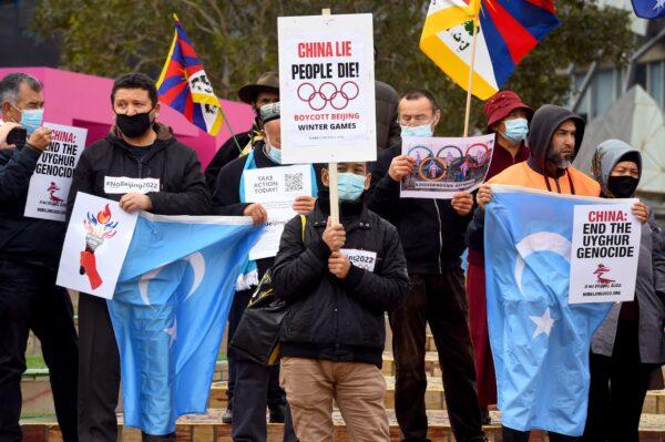 Activists including members of the local Hong Kong, Tibetan and Uyghur communities hold up banners and placards in Melbourne, Australia, on June 23, 2021, calling on the Australian government to boycott the 2022 Beijing Winter Olympics over China's human rights record. (William West/AFP via Getty Images)