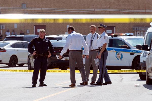 Law enforcement officials confer near a mall parking area in Baltimore, Md., on July 13, 2021. (Jose Luis Magana/AP Photo)