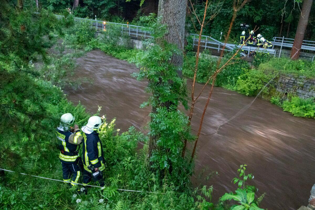 Firefighters search for a missing person at the Steinbach after a flash flood had swept the individual away during a storm in Jöhstadt (Erzgebirgskreis), in Germany, on July 13, 2021. (Andre März/dpa via AP)