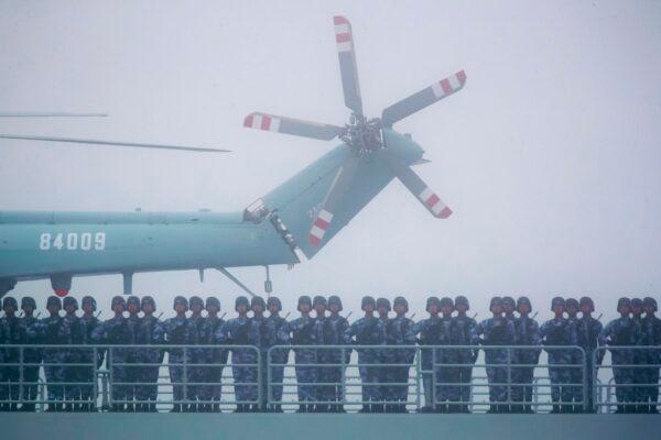 Soldiers stand on the deck of the transport dock Yimen Shan of the Chinese People's Liberation Army (PLA) Navy in the sea near Qingdao in eastern China's Shandong province, on April 23, 2019. (Mark Schiefelbein/AFP via Getty Images)