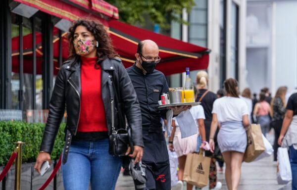 A waiter wearing a face mask to protect against coronavirus serves customers at the Champs Elysees avenue in Paris, on July 12, 2021. (Michel Euler/AP Photo)