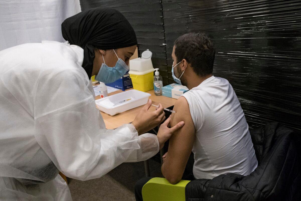 A nurse administrates the Pfizer COVID-19 vaccine to Thibaut Razafinarivo, 26, in a vaccination center in Versailles, west of Paris, on July 13, 2021. (Constantin Gouvy/AP Photo)
